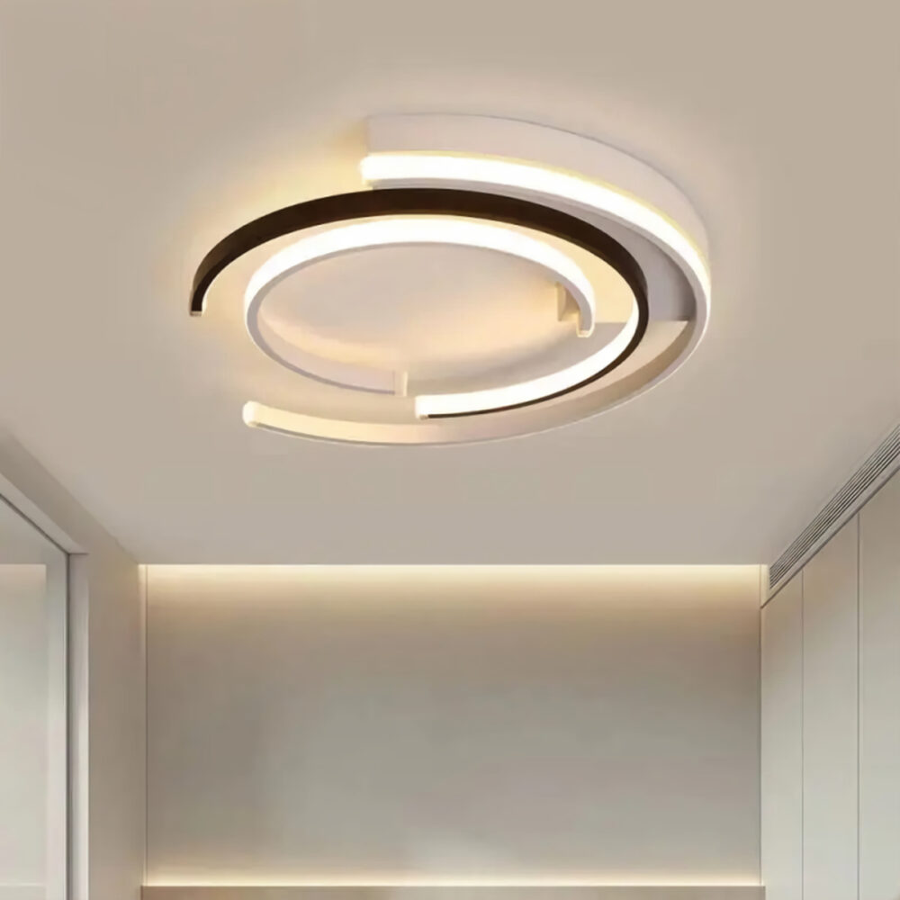 Plafonnier plat et rond en aluminium design moderne de couleur blanc et noir fixé au plafond.