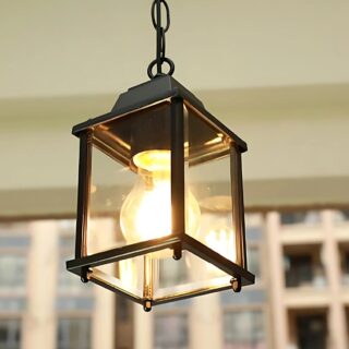Plafonnier extérieur style lanterne suspendue en métal noir aux quatre faces en verre. L'ampoule allumée est visible.