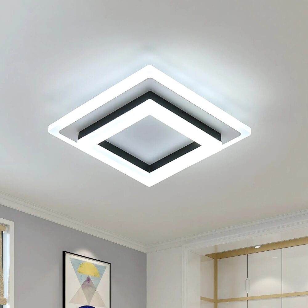 Plafonnier LED carré avec trois carrés superposés, un noir entre deux lumineux. Le plafonnier est fixé sur un plafond blanc.