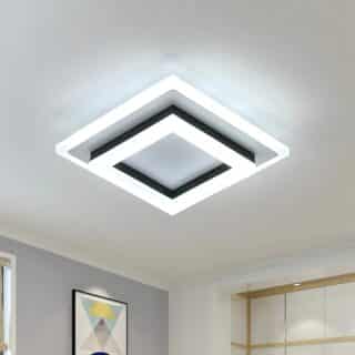 Plafonnier LED carré avec trois carrés superposés, un noir entre deux lumineux. Le plafonnier est fixé sur un plafond blanc.