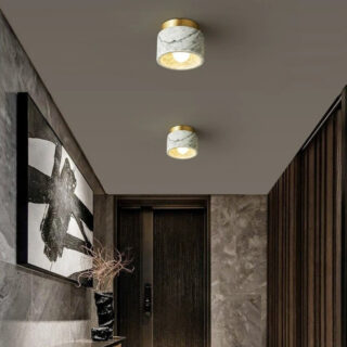 Plafonnier salle de bain en marbre dans sa version blanche. On dustingue une toile peinte sur le mur de gauche et ce qui semble être des meubles en bois sur le côté droit.