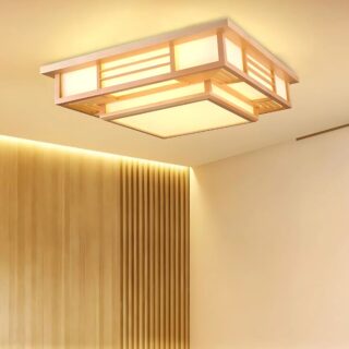 Plafonnier salon de style japonais en bois de forme carrée. Il est allumé et diffuse une lumière jaune à travers les panneaux blancs. Un mur marron sur la gauche.