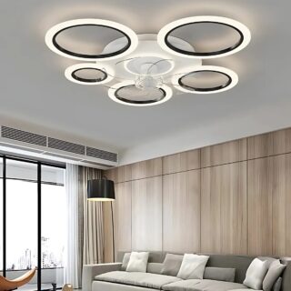 Plafonnier ventilateur 5 cercles lumineux blanc avec l'intérieur des cercles noirs. L'extérieur des cercles est un cercle de LED allumé. Il est fixé dans un salon avec un canapé beige sur un mur marron. Une grande fenêtre se trouve à gauche.