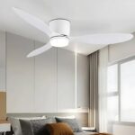 Plafonnier ventilateur à trois pales blanc avec un éclairage LED au centre des pales. Fixé dans une chambre avec un lit deux places.