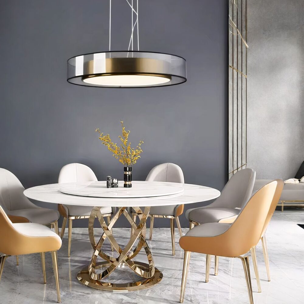 Plafonnier rond suspendu au dessus d'une table de salle à manger, avec un effet cuivré et un abat-jour transparent autour