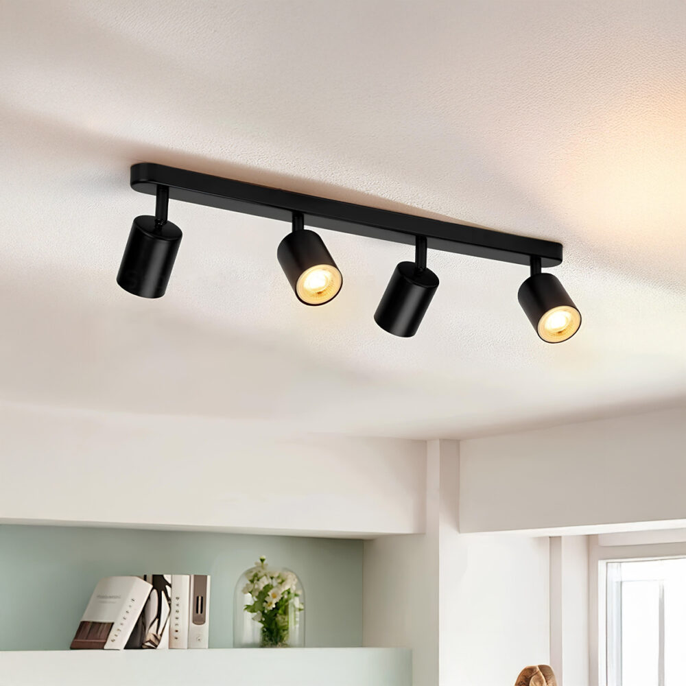 plafonnier spot minimaliste noir contenant 4 spot illuminant de part et d'autre sur un plafond blanc