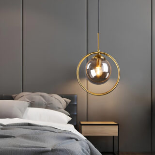 Plafonnier suspendu en verre cerclé pendant à côté d'un lit dans une chambre au mur gris