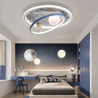 Plafonnier LED avec lune et astronaute. De forme ronde avec une imitation de la surface de la lune, une sphère blanche, un anneau bleu et un astronaute blanc et doré posé sur l'anneau bleu. La lumière est à LED et diffusée par les contour de la lune, l'anneau et la sphère. Fixé dans une chambre avec un lit, un bureau et une chaise bleue. Le mur en face est un ciel étoilé. Le mur de droite est bleu.