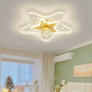 Plafonnier chambre bébé en forme d'étoile lumineuse en acrylique avec le centre de couleur dorée. Une boule transparente se trouve au centre de l'étoile. Fixé dans une chambre avec le mur de droite de couleur verte, une tête de lit blanche et sur la gauche une fenêtre.