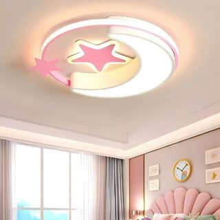 Plafonnier chambre enfant lune et étoiles de forme ronde et plate. Le cercle, la lune et une étoile ont les contours lumineux. Fixé au centre d'une chambre enfant dans les tons roses avec un lit, une grande fenêtre avec des rideaux gris sur la gauche.