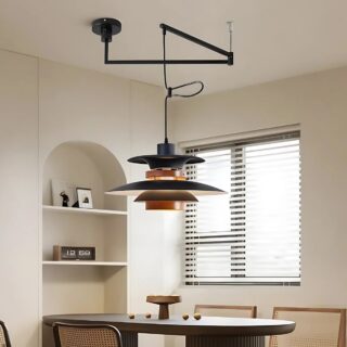 Plafonnier déporté chic et moderne de couleur noir et couleur bois avec un design multicouches. Il est composé de deux bras rotatifs noirs et l'abat-jour multicouches est suspendu. Fixé dans une pièce avec une étagère intégrée dans le mur de gauche et une table rectangulaire en bois foncé sous le plafonnier. Sur la droite une fenêtre.