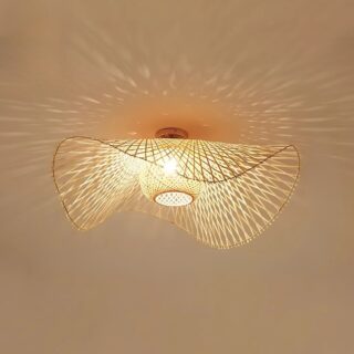 Plafonnier naturel en rotin style capeline avec une ampoule allumée diffusant une lumière à travers le tressage. Fixé sur un plafond beige.