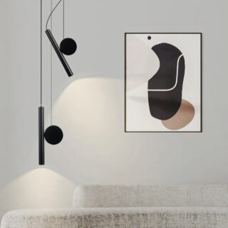 Plafonnier orientable haute précision en forme de pendentif noir mit en situation dans un salon éclairant un tableau et un canapé.