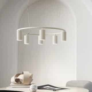 Plafonnier design à lumière orientable blanc de forme circulaire suspendu au-dessus d'une table.