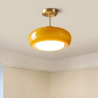 Plafonnier vintage rond en verre orange tenu par une tige dorée fixée sur le plafond. Un globe au centre diffuse une lumière blanche.