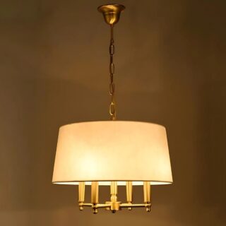 Plafonnier vintage style chandelier avec abat-jour en tissu blanc. Les ampoules diffusent un éclairage jaune. Suspendu par une chaine dorée sur un fond marron.