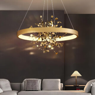 Plafonnier suspendu en feuillage cuivré pendant au dessus d'un canapé gris dans un salon aux murs foncés