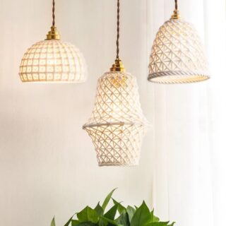 3 suspensions de formes différentes, en céramique blanche tressée au style japonais, suspendue devant un rideau blanc.