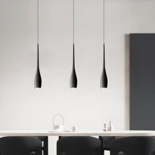 Un plafonnier scandinave en goutte d’eau minimaliste moderne noir avec trois suspensions fines, au-dessus d’une table dans une pièce claire et épurée.